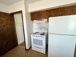 Grand Forks house for rent - an empty kitchen with a white stove and refrigerator