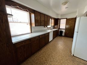 Grand Forks house for rent - an empty kitchen with a refrigerator and a window