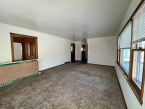 Manvel house for rent - an empty living room with carpet and windows
