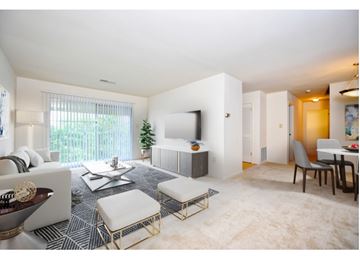 Baltimore apartment for rent - a living room and dining room with a couch and a tv