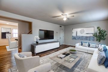 Baltimore apartment for rent - a living room with a white couch and a tv