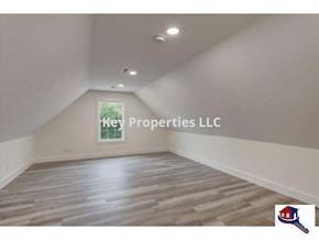 Loudon house for rent - A room with wooden flooring and a window showing greenery outside.