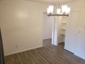 Anchorage apartment for rent - A chandelier hangs over a white door in a room with wood flooring.