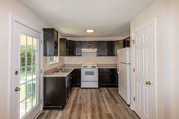 Jacksonville house for rent - A kitchen with black cabinets and white appliances.