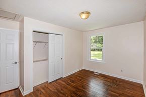 Jacksonville house for rent - A room with a white door and a window with a view of a lawn and trees.