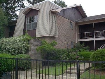 Hattiesburg house for rent - a brick house with a yard and a fence