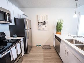 Salt Lake City apartment for rent - A kitchen with a black fridge and stove top oven.