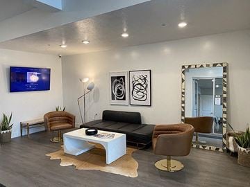 Salt Lake City apartment for rent - A modern living room with a white coffee table and a flat screen TV mounted on the wall.