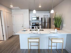 Salt Lake City apartment for rent - A kitchen with a white counter and two gold chairs.