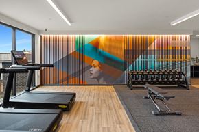 Seattle apartment for rent - A gym with treadmills, weights and a colorful mural on the wall.