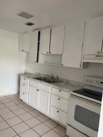Fort Myers apartment for rent - A kitchen with white cabinets and appliances.