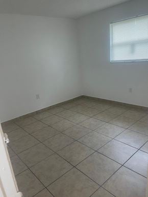 Fort Myers apartment for rent - A room with tiled flooring and a window with blinds.