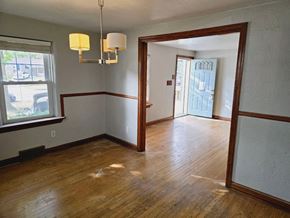 St. Louis house for rent - a dining room and living room with wood floors and white walls