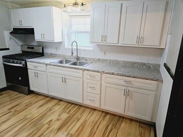 St. Louis house for rent - a kitchen with white cabinets and granite counter tops