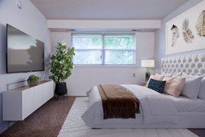 Baltimore apartment for rent - A bedroom with a large bed and a television on the wall.