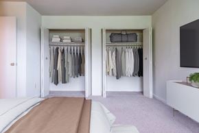 Baltimore apartment for rent - A bedroom with a bed and a closet with clothes hanging.