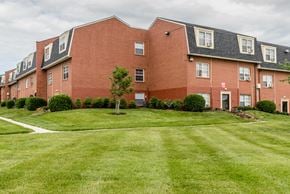 Baltimore apartment for rent - A red brick building with a green lawn in front.