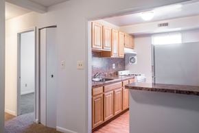 Baltimore apartment for rent - A kitchen with wooden cabinets and a white fridge.