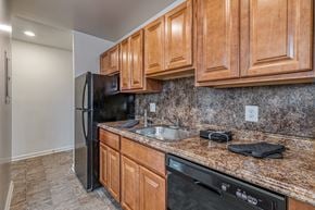 Baltimore apartment for rent - A kitchen with wooden cabinets and granite countertops.