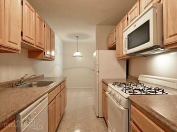 Windsor Mill apartment for rent - A kitchen with wooden cabinets and a stove top oven.