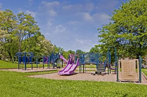 Baltimore apartment for rent - A playground with a purple slide and a green tree.