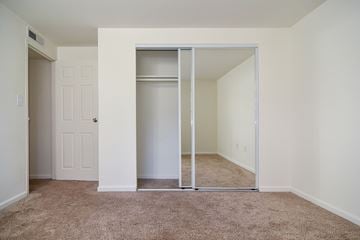 Baltimore apartment for rent - a spacious living room with white walls and carpet and a window