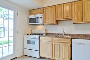 Frederick apartment for rent - A kitchen with wooden cabinets and white appliances.