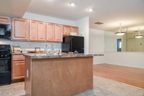 Owings Mills apartment for rent - A kitchen with a brown counter and black appliances.