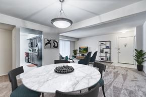 Sykesville apartment for rent - A white marble dining table with a bowl of decorative rocks in the middle and green chairs around it.