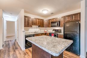 Glen Burnie apartment for rent - A kitchen with wooden cabinets and a granite countertop.