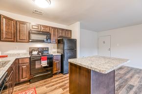 Glen Burnie apartment for rent - A kitchen with dark wood cabinets and appliances.