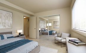 Baltimore apartment for rent - A bedroom with a large bed and a mirrored closet door.