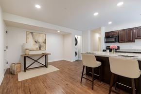 Glen Burnie apartment for rent - A living room with a white couch, a chair, a coffee table, and a television.