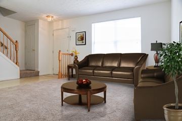 Glen Burnie apartment for rent - A living room with a brown leather couch and a coffee table.