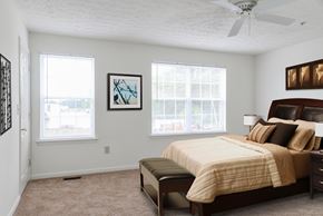 Glen Burnie apartment for rent - A bedroom with a bed, a bench, and two windows.