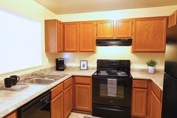 Hagerstown apartment for rent - A kitchen with a white refrigerator, black dishwasher, and a white stove top oven.
