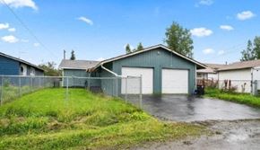 Anchorage house for rent - a blue house with a fence and a garage