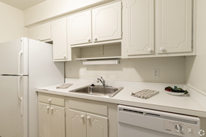 Westland apartment for rent - a kitchen with white cabinets and a sink and a refrigerator