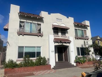 Long Beach apartment for rent - A white two-story house with a brown roof and a brown door.