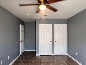 Gulfport apartment for rent - A room with a ceiling fan and two doors.