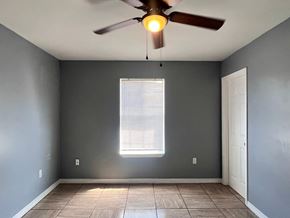 Gulfport apartment for rent - A room with a ceiling fan and a window with blinds.