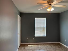 Gulfport apartment for rent - A room with a ceiling fan and a window with blinds.