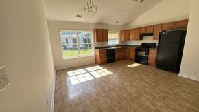 Pocomoke house for rent - an empty kitchen with black appliances and a window
