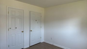 Pocomoke house for rent - a bedroom with two closets and a tiled floor and two doors