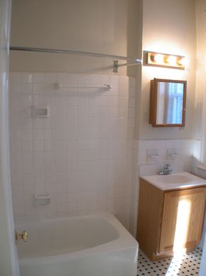 Washington apartment for rent - A white tiled bathroom with a white tub and sink.