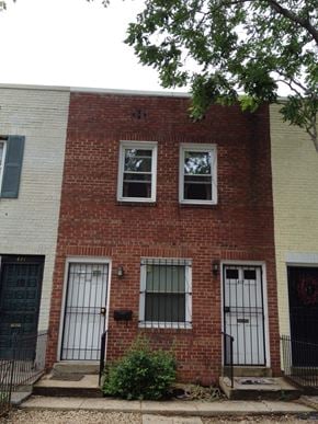Washington apartment for rent - A red brick house with a black gate in front.