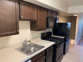 Washington apartment for rent - A kitchen with black appliances and wooden cabinets.