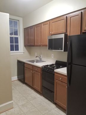 Washington apartment for rent - an empty kitchen with black appliances and wooden cabinets