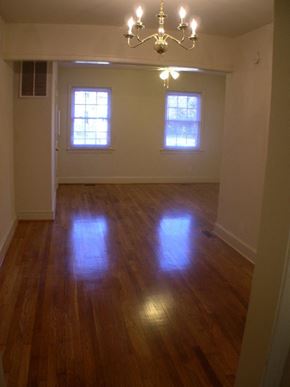 Washington apartment for rent - A room with a chandelier and two windows.