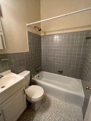 Washington apartment for rent - A bathroom with a white toilet and a white bathtub.